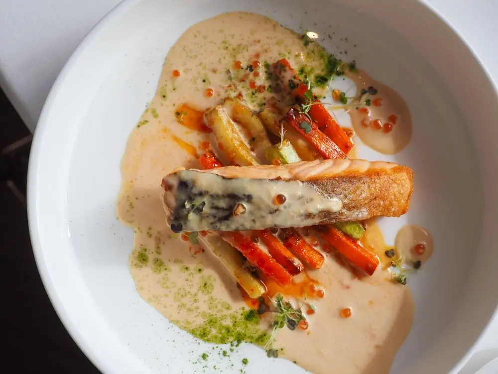 Carefully assembled seafood entrée with seasonal root vegetables