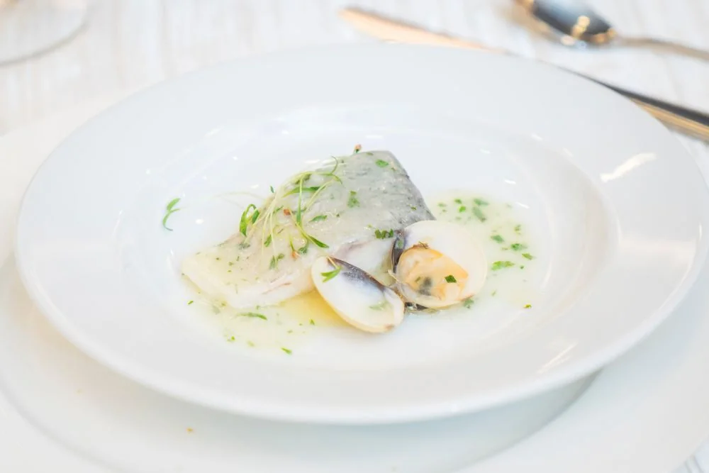 Artistic presentation of delicate clams and ocean greens served on porcelain