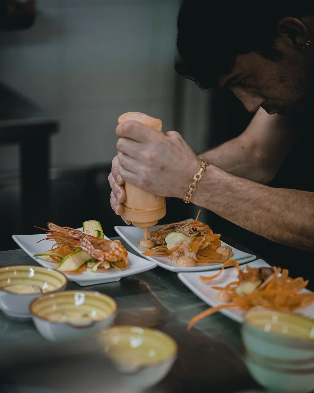 Chef in uniform carefully plating a refined seafood presentation