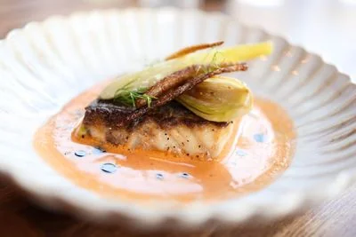 Pan-roasted fish fillet served over braised greens and fine reduction