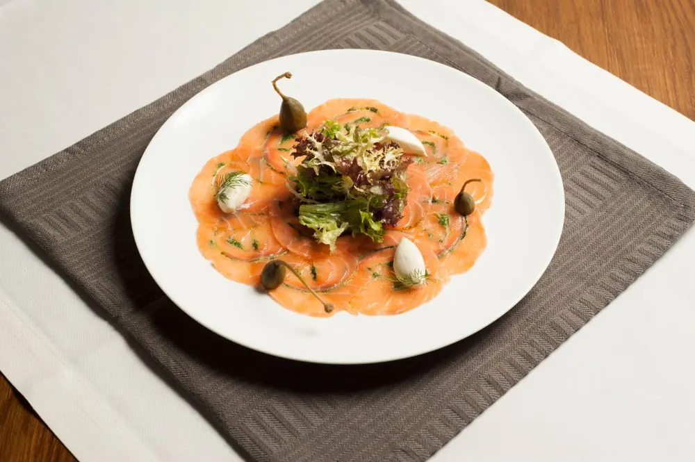 Freshly plated seafood carpaccio with citrus drizzle and capers