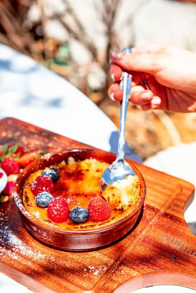Vanilla Crème Brûlée with crisp caramel crust and berry garnish